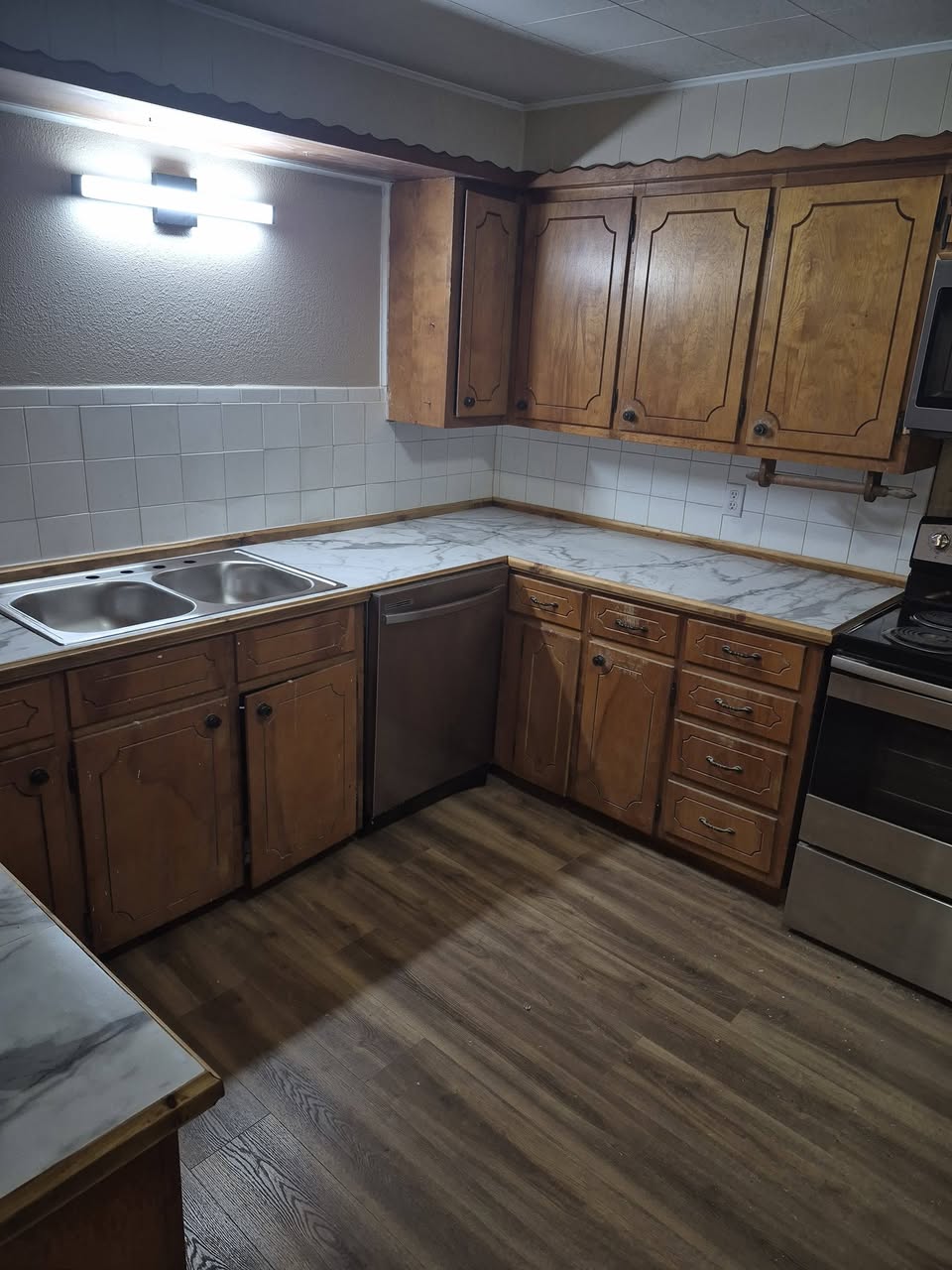 Kitchen remodel with updated flooring, counters, sink, and dishwasher
